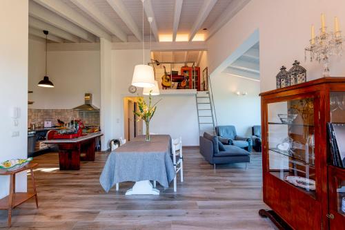 a living room with a table and a couch and a staircase at Dimora Campo delle Mura - Charming House in Acquaviva Picena