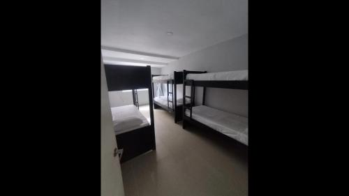 a room with three bunk beds and a hallway at Bm-15 room near the sea with air conditioning and WIFI in Cartagena de Indias