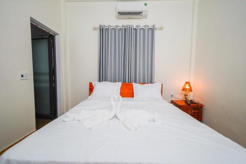 a bedroom with a large white bed with white sheets at Phong Nha Magic Fingers Homestay and Spa in Phong Nha