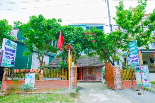 a small house with a fence with signs in front of it at Phong Nha Magic Fingers Homestay and Spa in Phong Nha