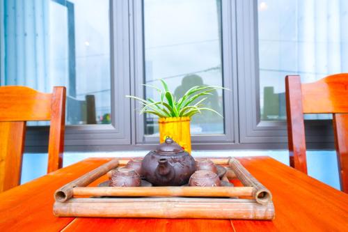 a vase sitting on a wooden table with a plant at Phong Nha Magic Fingers Homestay and Spa in Phong Nha
