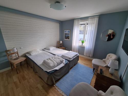 um quarto com uma cama, uma cadeira e uma janela em Slussen Rum Söderköping em Söderköping