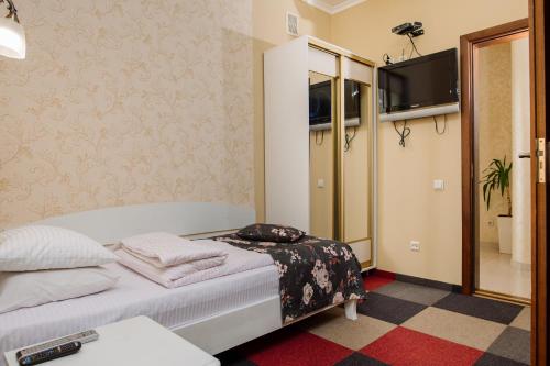 a small bedroom with a bed and a tv at Na Horyzonti in Truskavets