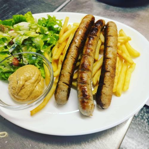 a plate with three sausages and french fries and a salad at Gasthof Schönblick Rußbach in Gseng