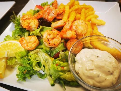 a plate of food with shrimp and lettuce and french fries at Gasthof Schönblick Rußbach in Gseng