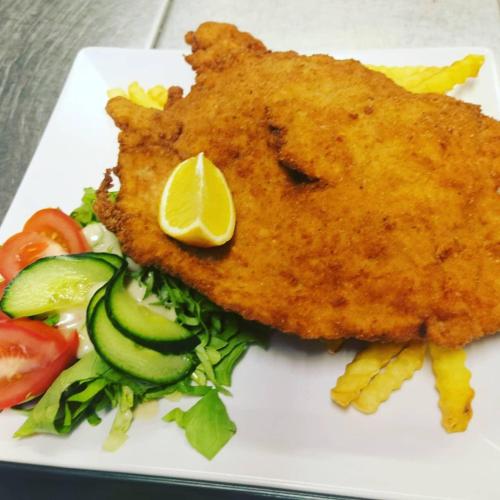 a plate of food with a piece of fish and vegetables at Gasthof Schönblick Rußbach in Gseng