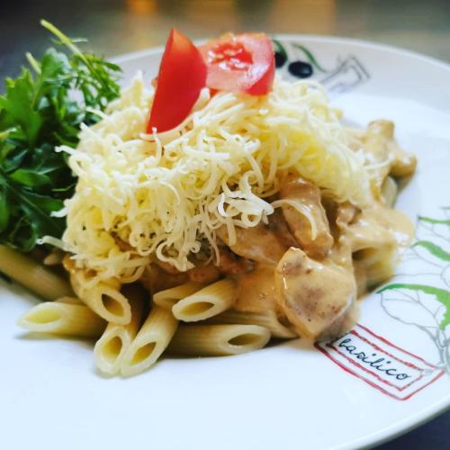 a plate of pasta with meat and cheese and a salad at Gasthof Schönblick Rußbach in Gseng