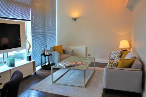 a living room with a couch and a coffee table at Penthouse in Old Street in London