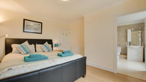 1 dormitorio con 1 cama grande y toallas azules. en Carreg Lwyd Farmhouse, en Port Eynon