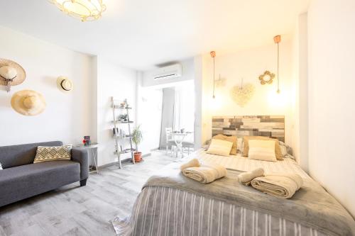 ベナルマデナにあるCozy Flat Manuela Costa del Solのベッドルーム(大型ベッド1台、ソファ付)