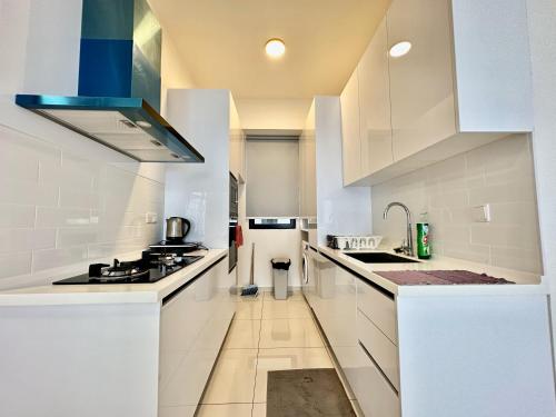 a kitchen with white cabinets and a stove top oven at Beacon Executive Suites #Georgetown #InfinityPool #15 in George Town