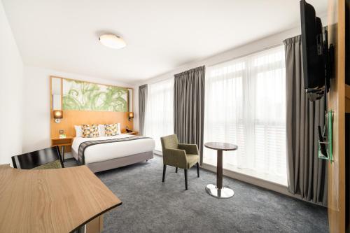 a hotel room with a bed and a table at Holiday Inn Birmingham City, an IHG Hotel in Birmingham