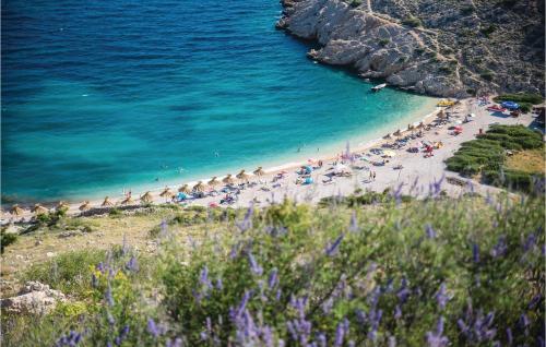 a beach with a bunch of people and the ocean at Stunning Apartment In Stara Baska in Stara Baška