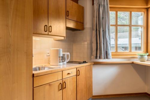 a kitchen with wooden cabinets and a sink and a window at Taufner Apartement C 103 in Parcines