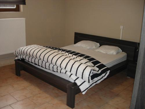 a bed with a black and white blanket on it at appartement Courcelles in Courcelles