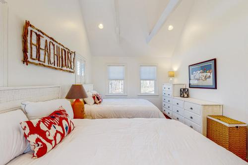 a white bedroom with two beds and a dresser at Edgartown Retreat in Edgartown