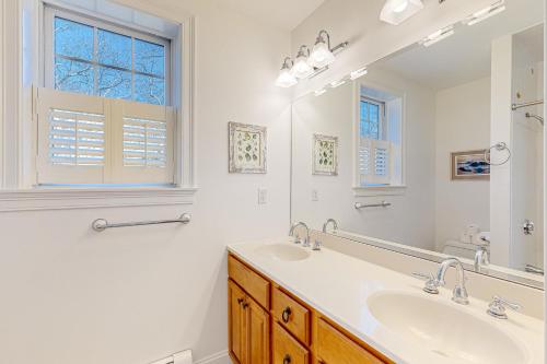 a white bathroom with a sink and a mirror at Edgartown Retreat in Edgartown
