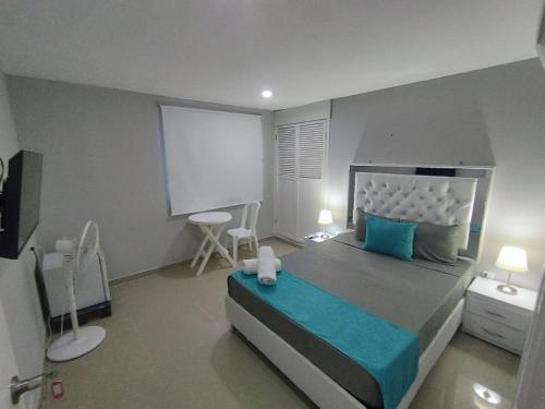 a bedroom with a large bed with blue pillows at Bm-9 room near the sea with air conditioning and WIFI in Cartagena de Indias