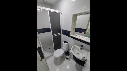 a bathroom with a toilet and a sink and a mirror at Bm-9 room near the sea with air conditioning and WIFI in Cartagena de Indias