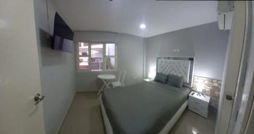 a small bedroom with a bed and a window at Bm-4 room near the sea with air conditioning and WIFI in Cartagena de Indias
