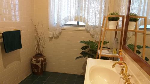 a bathroom with a sink and a window at Sweet Holiday Home by the Golf Course in Canberra