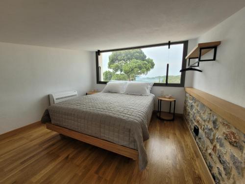 1 dormitorio con cama y ventana grande en Skiathea Villas, en Agia Paraskevi