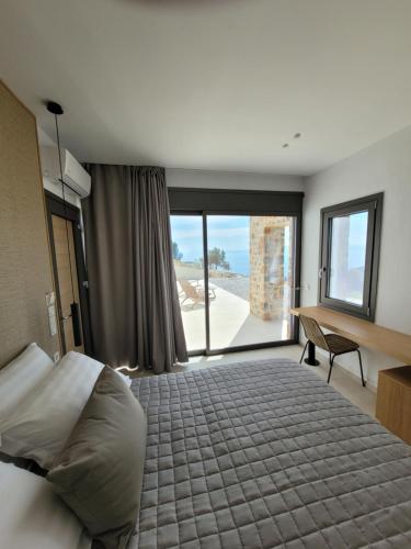 1 dormitorio con cama grande y ventana grande en Skiathea Villas, en Agia Paraskevi