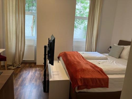 a bedroom with two beds and a television on a desk at Grand Central Station Apartments I contactless check-in in Vienna
