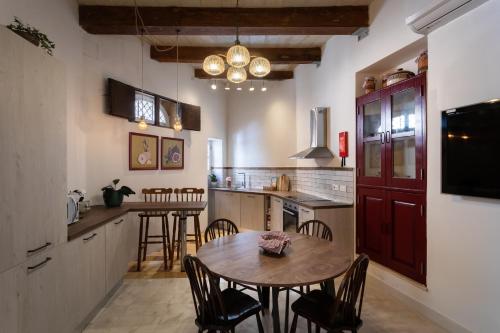 a kitchen with a table and chairs in a room at Authentic Maltese 2-bedroom House with Terrace in Żejtun