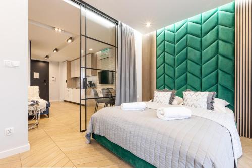 1 dormitorio con 1 cama grande y cabecero verde en Apartment Antalovka Residence & Spa en Zakopane