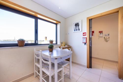 a waiting room with a table and chairs and a window at Margarida Sun House Ocean View in Raposeira