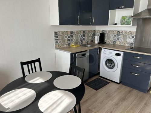 une cuisine avec une table et une machine à laver dans l'établissement Cosy F2 Fresnes-Près de Paris, Orly et Rungis, à Fresnes