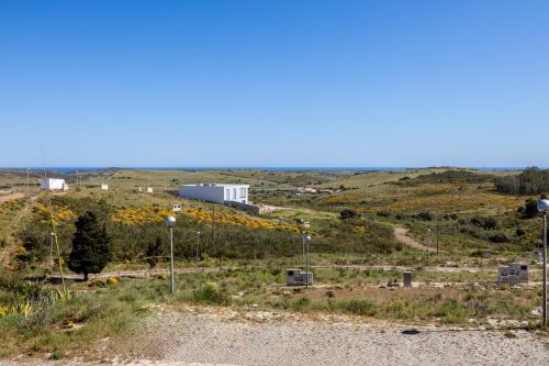 a view of a field with a building on a hill at Margarida Sun House Ocean View in Raposeira