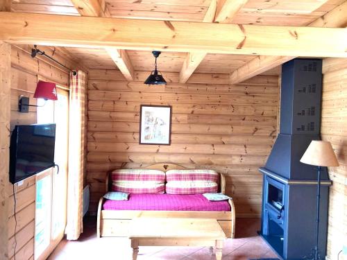 a room with a couch and a tv in a log cabin at Chalet les Hauts de la Lauzière in Le Dévoluy