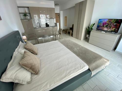 een slaapkamer met een groot bed en een keuken bij De Silva Studio Adia 4 in Mamaia