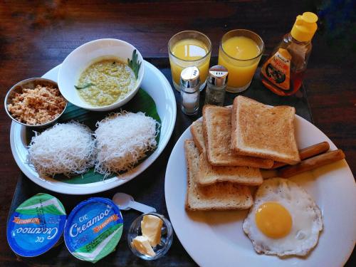 a table with two plates of food with eggs and toast at CHEN VILLA - Near Airport in Negombo