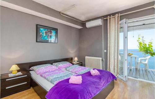 sypialnia z łóżkiem z fioletową pościelą i balkonem w obiekcie Lovely Apartment In Stara Baska w mieście Stara Baška