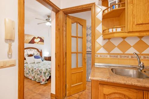 a kitchen with a sink and a room with a bed at Las Arenas bajo in La Mareta