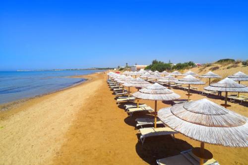 eine Reihe von Sonnenschirmen und Stühlen am Strand in der Unterkunft Villa Antony piano terra in Granelli