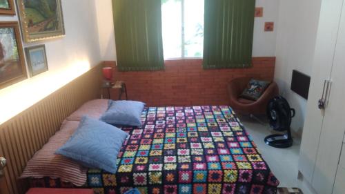 1 dormitorio con 1 cama con edredón en Sítio Sapiranga en Sapiranga