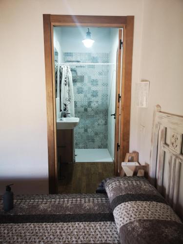 a bathroom with a bed and a shower with a sink at Casa Rural El Llano Quintanilla in Yecla
