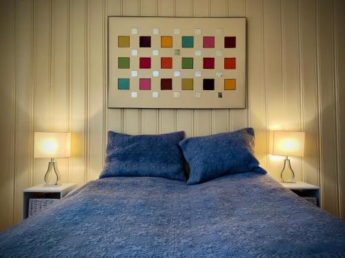 a bedroom with a blue bed with two lamps at Nordgards Hagen in Lillehammer
