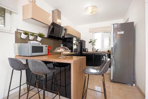 a kitchen with a refrigerator and a counter with stools at Holiday Home Roko&Iva in Brodarica