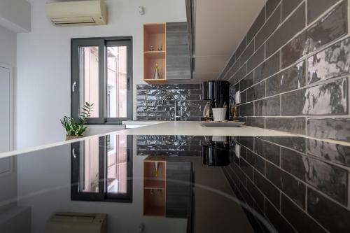 a kitchen with black and white tile on the wall at Napier Maisonette in Argostoli
