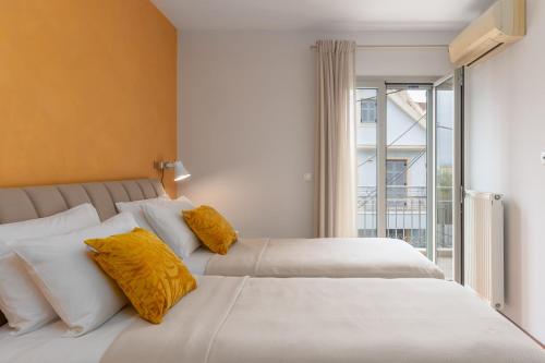 a bedroom with two beds with yellow pillows and a window at Napier Maisonette in Argostoli