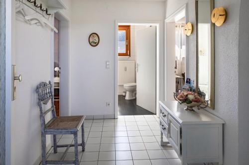 Habitación con baño con lavabo y silla. en Ferienwohnung Trixi, en Sexau