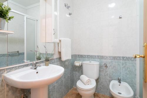 Puerto MarinoにあるCasa en la playa con piscinas 11 Aの洗面台とトイレを備えた白いバスルーム