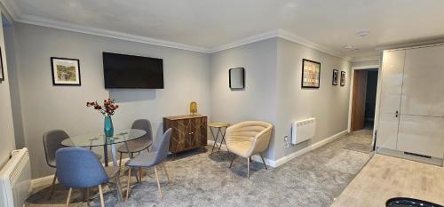 a living room with a table and chairs and a television at The Philog by Switchback Stays in Cardiff