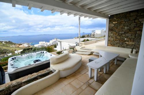 a patio with a jacuzzi tub on top of a house at Flaskos Village Fanari in Mýkonos City