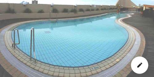 a large swimming pool with blue water at Riverbank suites 1008 in Kuching